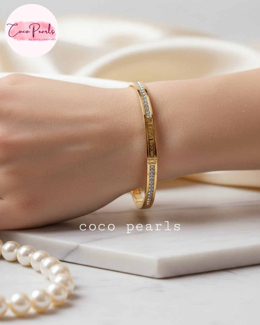 Coco Pearls Stainless Steel Anti Tarnish Gold Sparkle elegance handcuff bangle bracelet with diamond accents displayed on hand