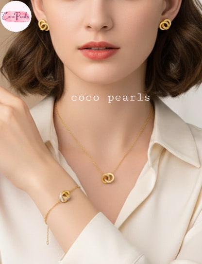 Coco Pearls Stainless Steel Anti tarnish Gold sparkle loop jewelry set with diamond studded necklace, earrings, and bracelet woman wearing it
