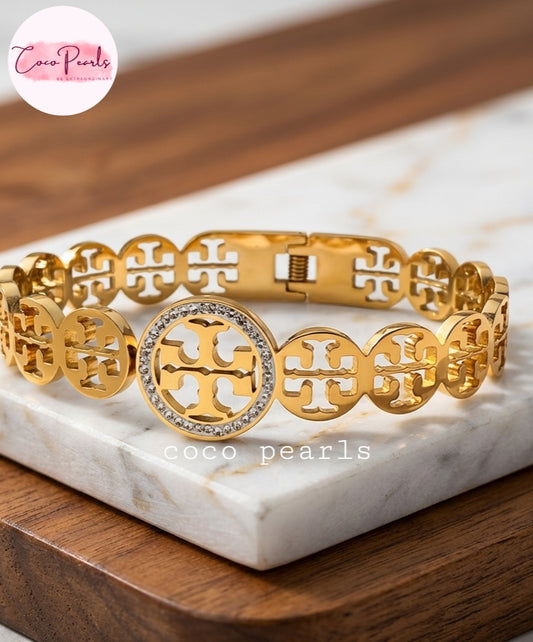Coco pearls stainless Steel anti tarnish gold sparkly vibe handcuff displyed on simple background 