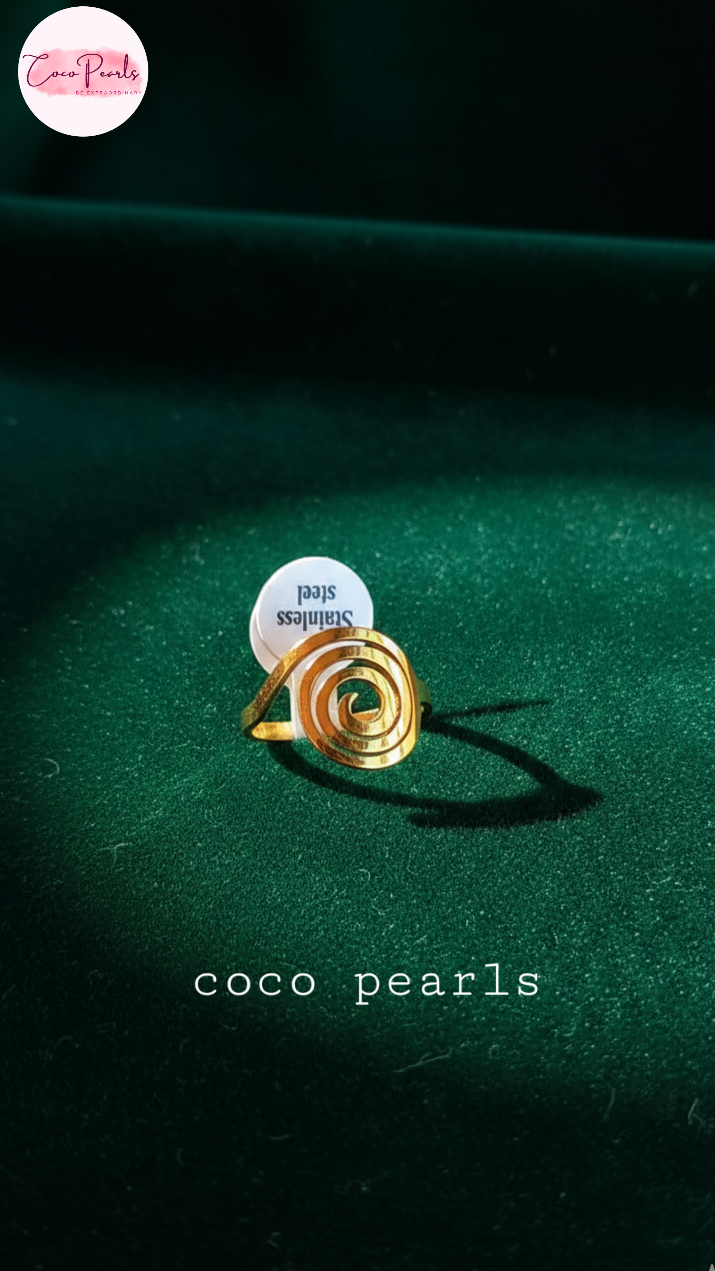 coco pearls stainless steel anti tarnish Gold spiral ring on a dark green fabric background 