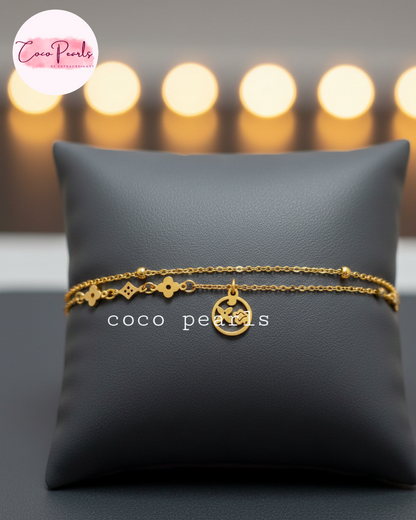 coco Pearls Stainless steel anti tarnish gold starlight bracelet wit dual chain and charm displayed on black cushion