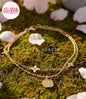 Coco Pearls Stainless steel Anti Tarnish Gold starry night anklet with charms on a green moss background with cherry blossom petals