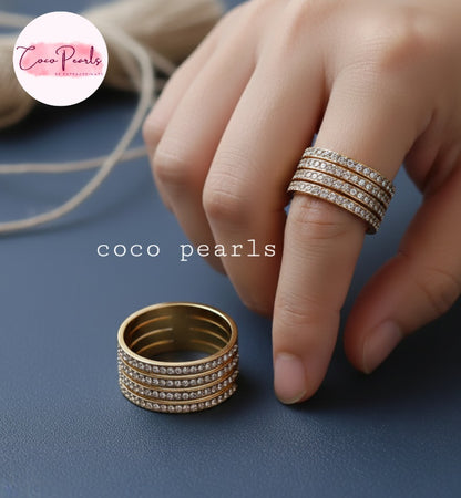 Coco Pearl stainless steel Anti tarnish  Gold stellar stack ring with 4 layer rhinestones on a blue surface
