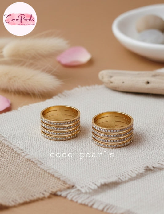 Coco Pearl stainless steel Anti tarnish  Gold stellar stack ring with rhinestones on a textured surface