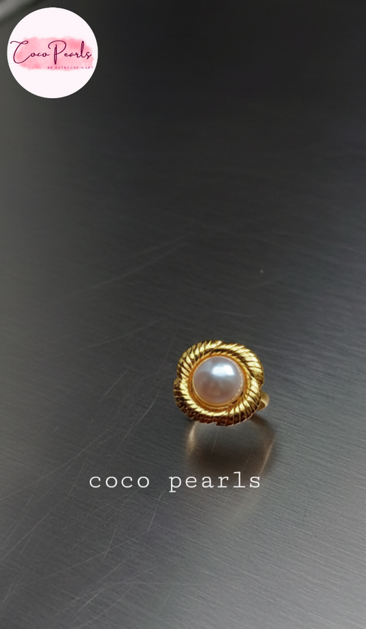 coco pearls stainless steel anti tarnish gold sun kissed pearl adjustable ring  with pearl in center of gold flower displayed on metallic surface