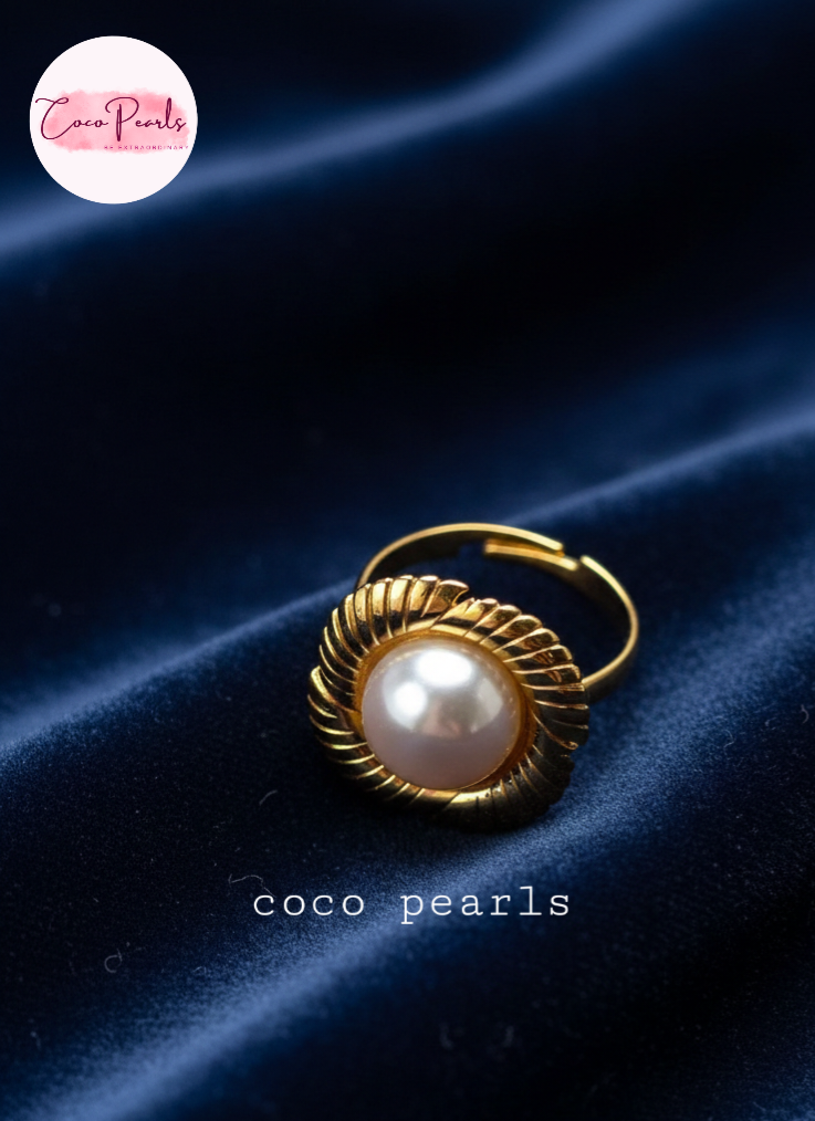coco pearls stainless steel anti tarnish gold sun kissed pearl adjustable ring  with pearl in center of gold flower displayed on blue satin