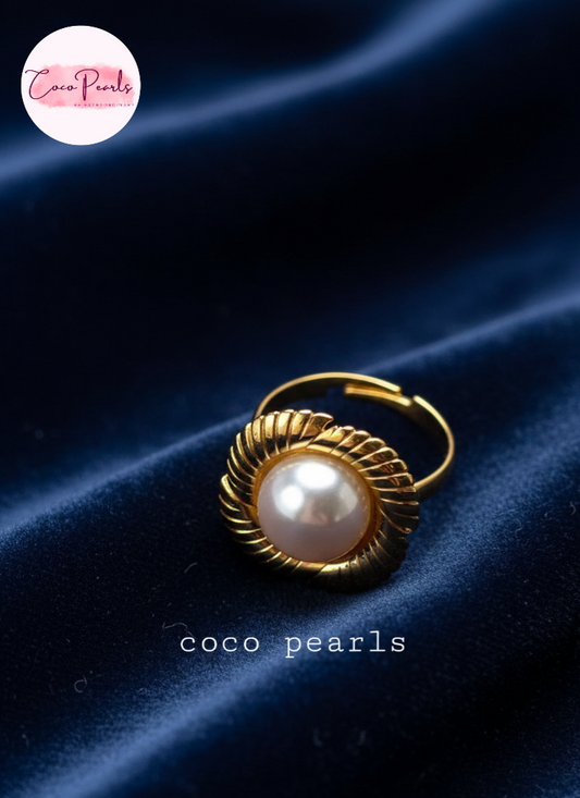 coco pearls stainless steel anti tarnish gold sun kissed pearl adjustable ring  with pearl in center of gold flower displayed on blue satin