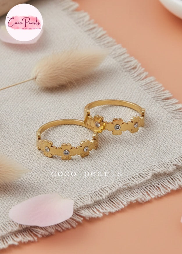Coco Pearls Stainless Steel Anti tarnish Gold sunshine bloom floral rings with a rhinestone on a simple background