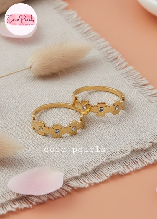Coco Pearls Stainless Steel Anti tarnish Gold sunshine bloom floral rings with a rhinestone on a simple background