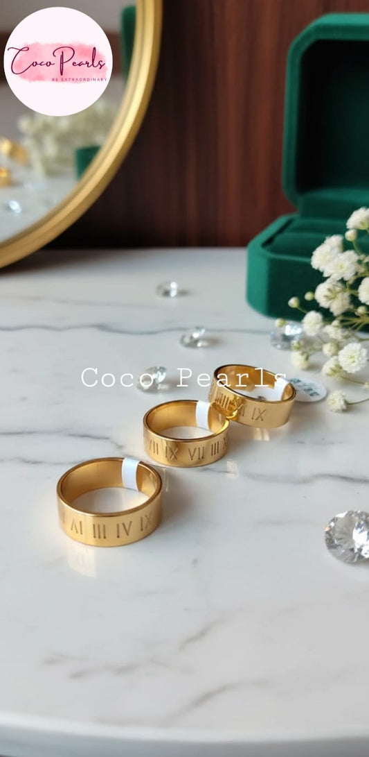 Coco Pearls Stainless Steel Anti Tarnish  gold timeless mark ring. roman numeral band on a simple background