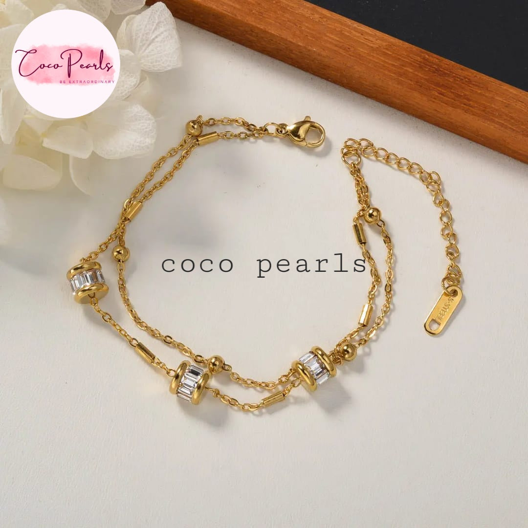 Coco Pearls Stainless steel anti tarnish Gold twinkle chain bracelet with pearl-like beads on a white surface