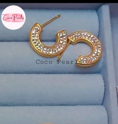 Coco Pearls Stainless Steel Anti Tarnish Gold hoop earrings with rhinestones on a blue cushion