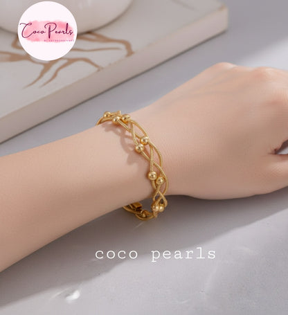 coco pearls stainless steel anti tarnish gold twisted braid bracelet with 3 ball chains twisted in a braid displayed on hand
