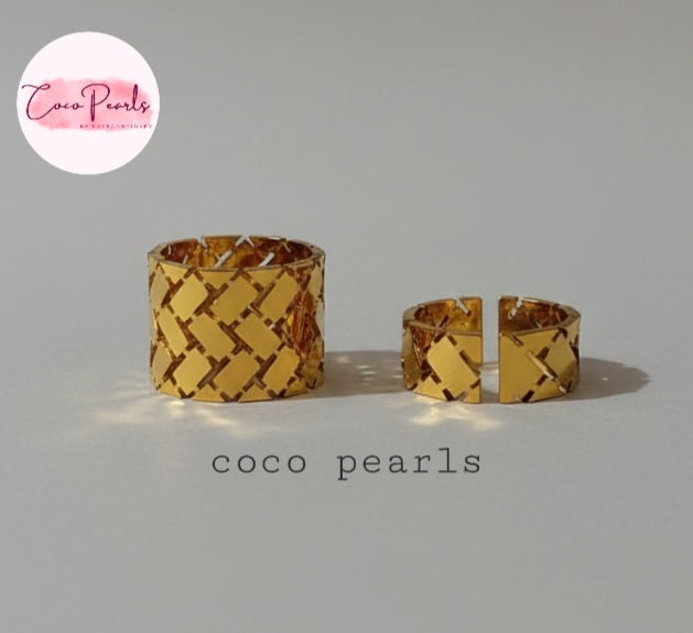 Tarnish Two gold woven rings with two different sizes with geometric pattern on a gray background, 