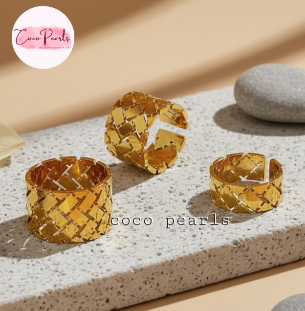 Tarnish Three gold woven rings wit geometrical design displayed on a textured surface with 'Coco Pearls' branding.