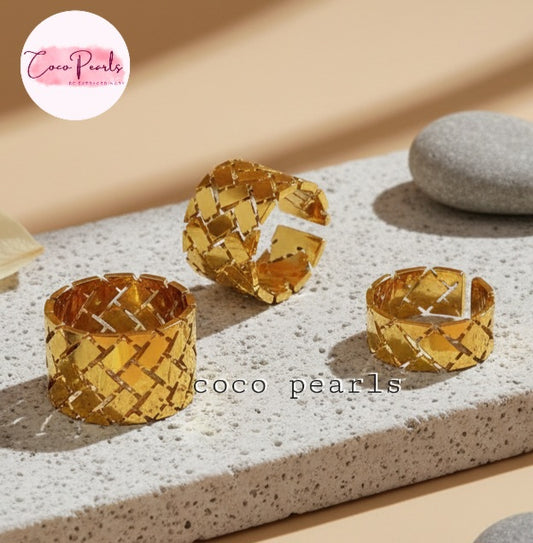 Tarnish Three gold woven rings wit geometrical design displayed on a textured surface with 'Coco Pearls' branding.