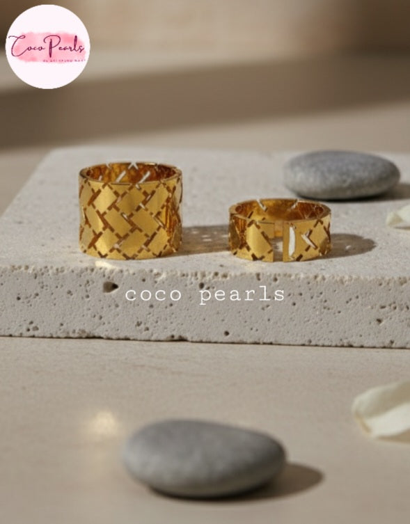 Coco earls Stainless steel Anti Tarnish Two gold woven rings with two different sizes on a textured surface